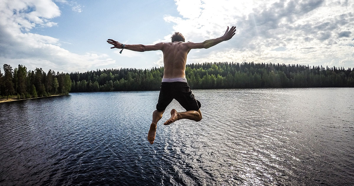 Mies hyppää järveen